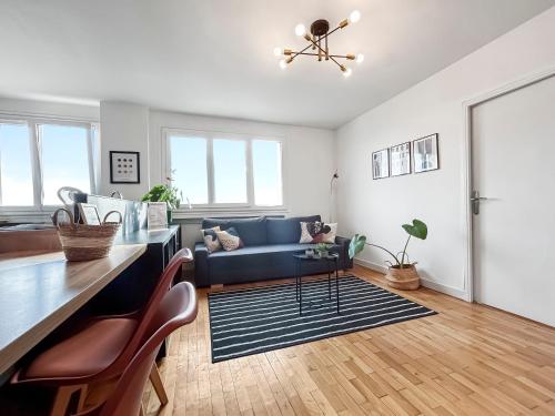 un salon avec un canapé bleu et une table dans l'établissement Cozy flat balcony panoramic view 5m metro B, à Oullins