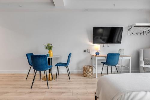 a room with blue chairs and a table and a tv at Initial / Simplicity / Québec in Quebec City