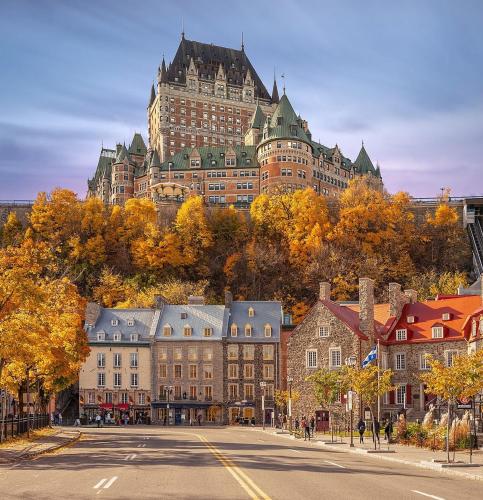 a large building on top of a hill with trees at Initial / Simplicity / Québec in Quebec City