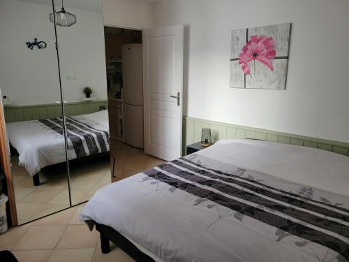 une chambre avec un lit et un miroir dans l'établissement bel appartement a vals les bains, à Vals-les-Bains