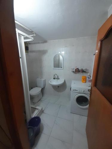a white bathroom with a toilet and a sink at Konar House in Istanbul