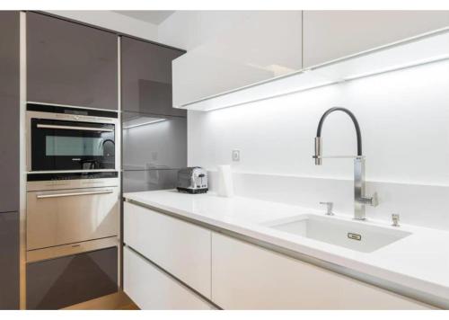a white kitchen with a sink and a microwave at Appartement de luxe Place Bellecour in Lyon