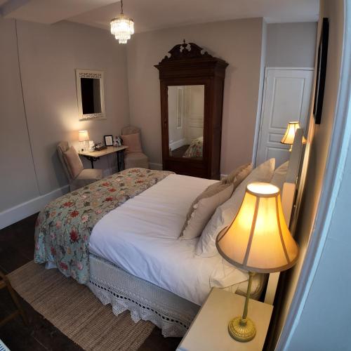 a bedroom with a bed and a table with a lamp at Repos à Ribérac B&B in Ribérac