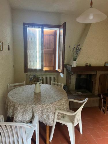 Un comedor con mesa y sillas y chimenea. en La casa nel cammino degli Dei, en Casa Sabbatino