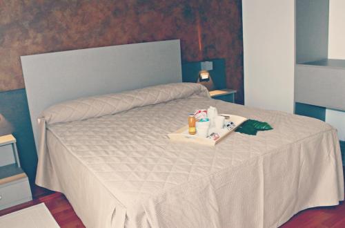 a bedroom with a bed with a tray of amenities at Halanus Hotel And Resort in Alanno