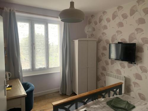 a bedroom with a bed and a tv on a wall at Webb's of Glomel in Glomel