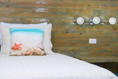 a bed with a pillow with a starfish on it at Hotel RH Boutique Aruba in Oranjestad
