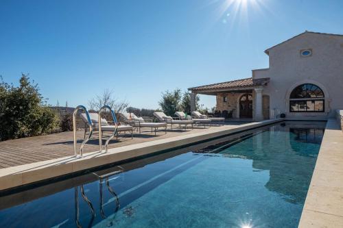 une piscine avec des chaises et une maison dans l'établissement Large property for rent in Provence Lavande et Merveilles, à Saint-Saturnin-lès-Apt
