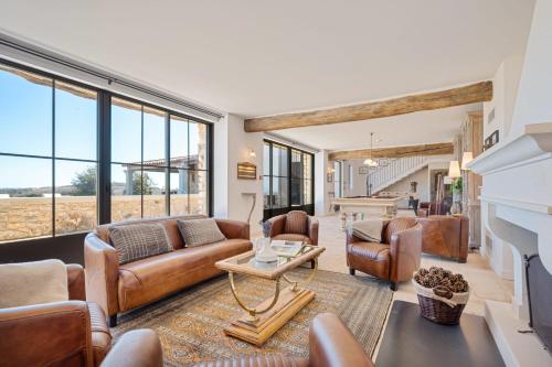 Elle comprend un salon doté d'un mobilier en cuir et d'une cheminée. dans l'établissement Large property for rent in Provence Lavande et Merveilles, à Saint-Saturnin-lès-Apt