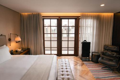 a hotel room with a bed and a chair at Hotel Fasano Sao Paulo in Sao Paulo