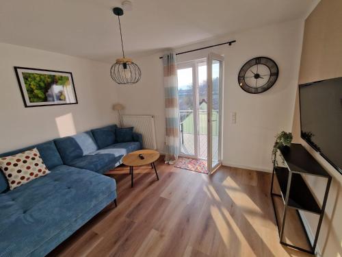 a living room with a blue couch and a tv at Ferienhaus Urlaub-in-Edenkoben in Edenkoben