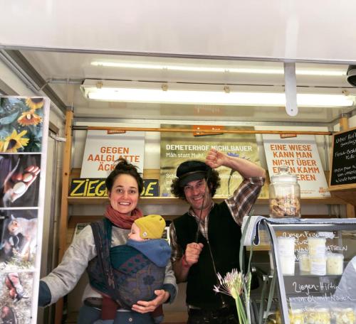 a man and a woman holding a baby in a store at Zinipi Lodge am Oldtimer am Demeterhof bei Amberg in Ursensollen