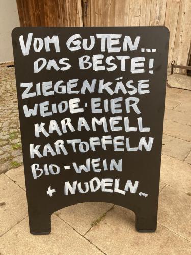 a sign sitting on the sidewalk with writing on it at Zinipi Lodge am Oldtimer am Demeterhof bei Amberg in Ursensollen