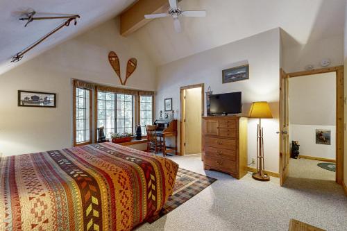 a bedroom with a bed and a dresser and a television at Circle 4 Ranch 31 | Discover Sunriver in Sunriver