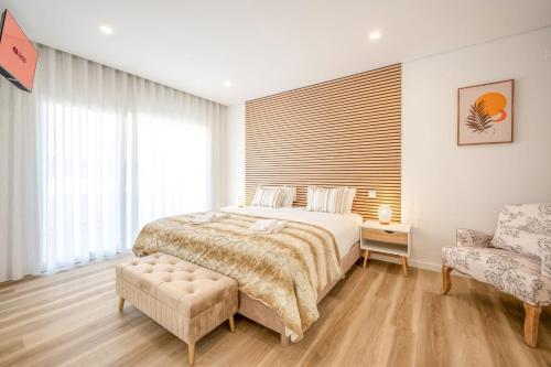 a bedroom with a large bed and a chair at GuestReady - Striking Hideaway in Almada in Charneca