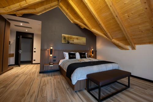 a bedroom with a large bed and wooden ceilings at PineHill Hotel, Restaurant , Pool & Spa - RAZEM in Razëm