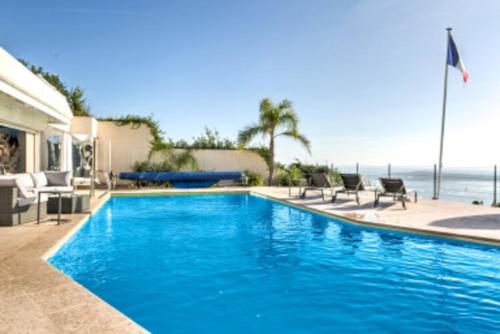une grande piscine bleue à côté de l'océan dans l'établissement Bas de Villa VUE PANORAMIQUE, à Vallauris