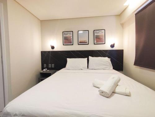 若昂佩索阿Flat Vista Mar em Manaíra Arpoar by Qavi的卧室里有一张白色的床，床上有两条毛巾