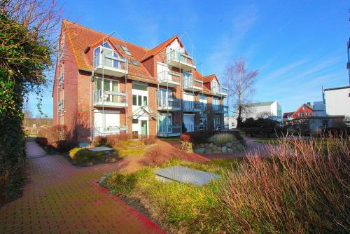 a large brick building with a yard in front of it at Strandduene Stranddüne Appartement 12 in Haffkrug