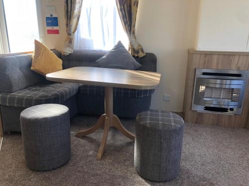 a living room with a table and two stools at Family friendly, 3-bedroom holiday home in Bembridge