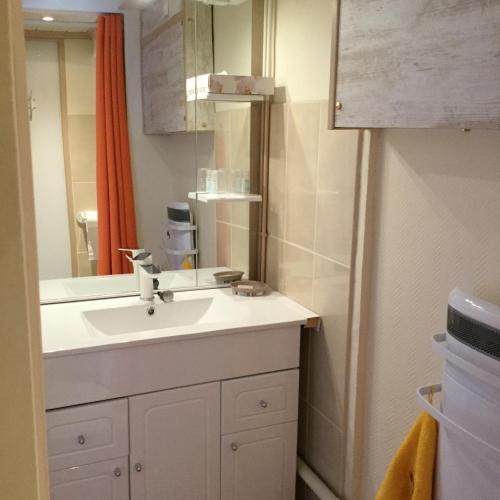 une salle de bain avec un lavabo et un miroir dans l'établissement Le Clos Joly, à Lamalou-les-Bains