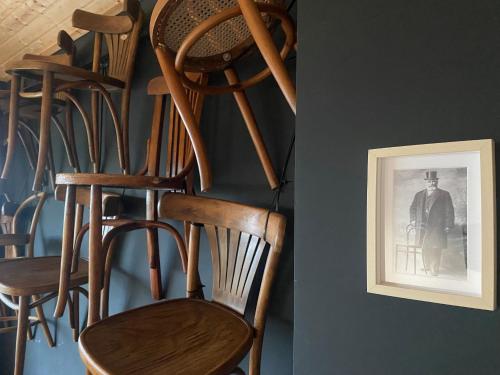 a group of wooden chairs sitting next to a wall at LUZZ me - Casa das Doze Ribeiras in Doze Ribeiras