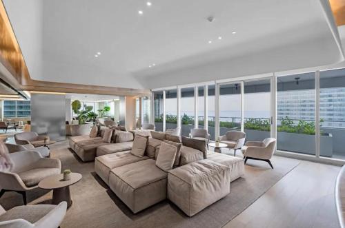 a large living room with couches and chairs and windows at Brickell Floor 31 Sea View-Free Parking by Palermo Home Miami in Miami