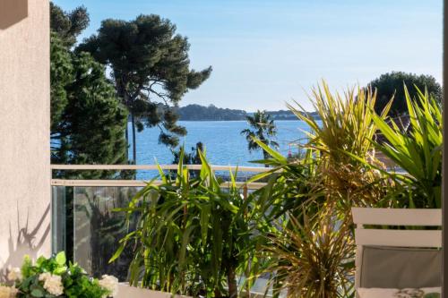 - un balcon avec des plantes offrant une vue sur l'eau dans l'établissement 3-Br Apartment Sea View Swimming Pool, à Cannes