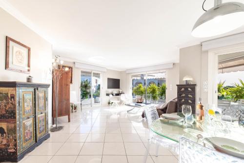 un salon avec une table en verre et des chaises dans l'établissement 3-Br Apartment Sea View Swimming Pool, à Cannes