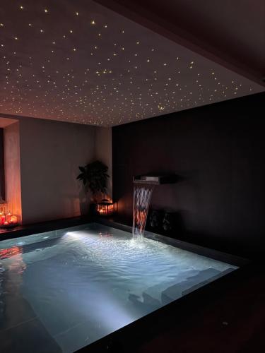 a swimming pool with a water fountain in a room at Il Grottino Relais & Spa in Gualdo Cattaneo