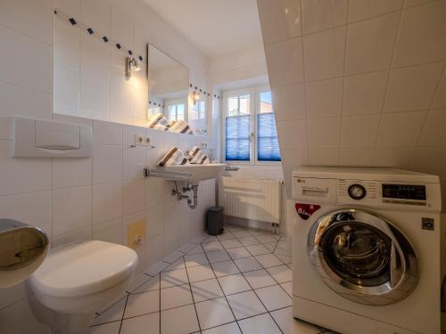 a bathroom with a washing machine and a sink at Landhaus St Niels in Westerland (Sylt)