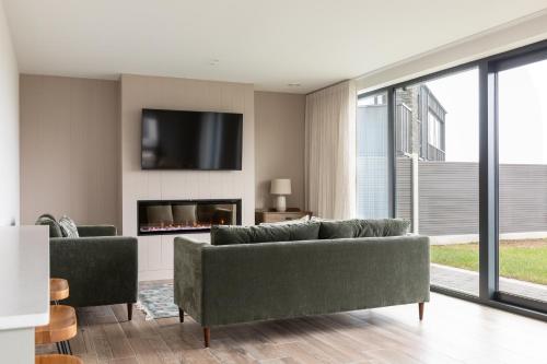 a living room with two couches and a fireplace at Binion at Ballyliffin Beach Houses, Pollan Bay in Ballyliffin