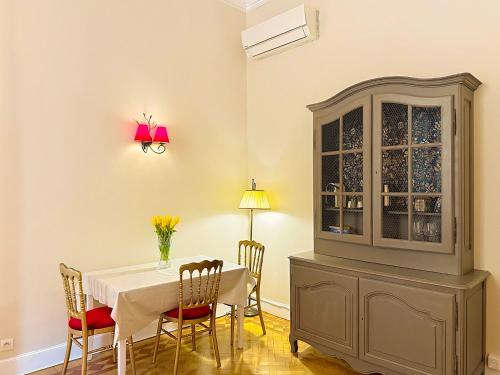 une salle à manger avec une table, des chaises et une armoire dans l'établissement Elegant Old Nice Escape, à Nice