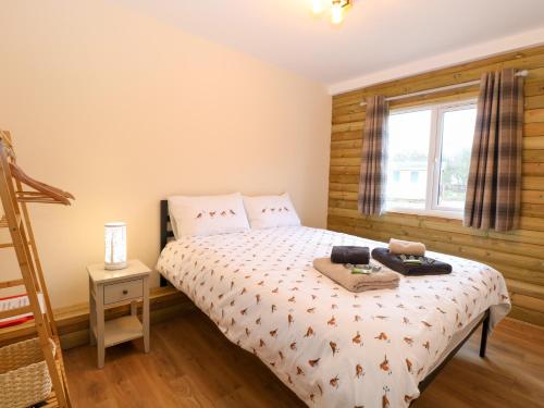 a small bedroom with a bed and a window at Robin's Nest Lodge in Snettisham