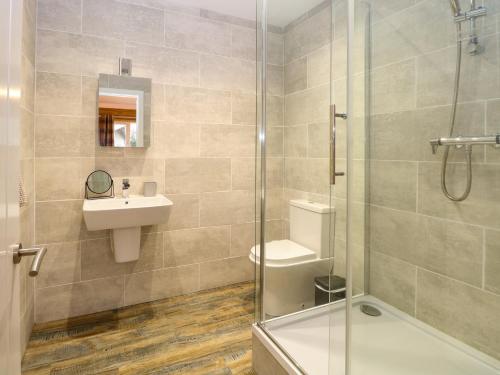 a bathroom with a shower and a sink and a toilet at Robin's Nest Lodge in Snettisham