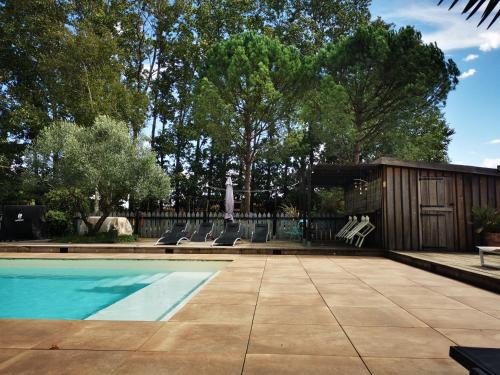 a swimming pool with lounge chairs next to a fence at Maison Basta in Orthevielle
