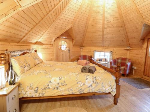a bedroom with a bed in a wooden room at Enchanted Cottage in Snettisham
