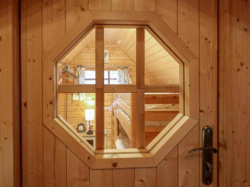 a small wooden cabin with a window in the door at Enchanted Cottage in Snettisham