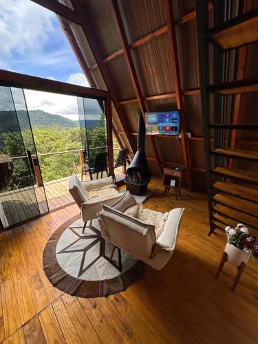 a living room with two chairs and a fireplace at Mirante Cabanas da Serra in Nonoai