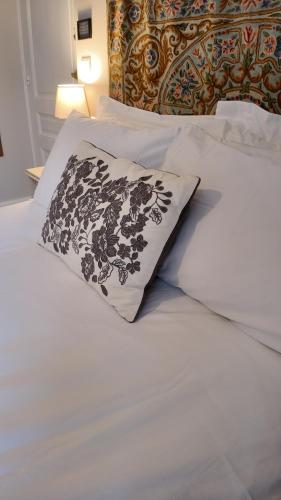 a bed with a black and white pillow on it at Repos à Ribérac B&B in Ribérac