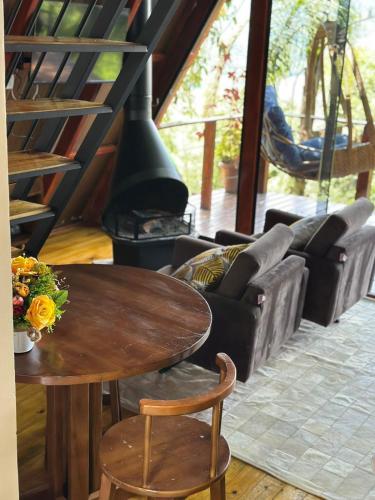 a living room with a wooden table and a fireplace at Mirante Cabanas da Serra in Nonoai