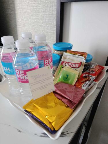 a table with bottles of water and other items on it at Spacious Staycation in Pasig Urban Metro Escape in Manila