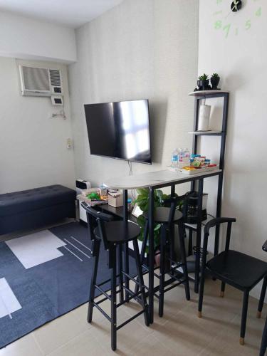a room with a desk with chairs and a tv at Spacious Staycation in Pasig Urban Metro Escape in Manila