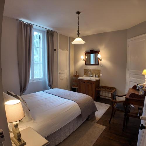 a bedroom with a bed and a sink and a mirror at Repos à Ribérac B&B in Ribérac