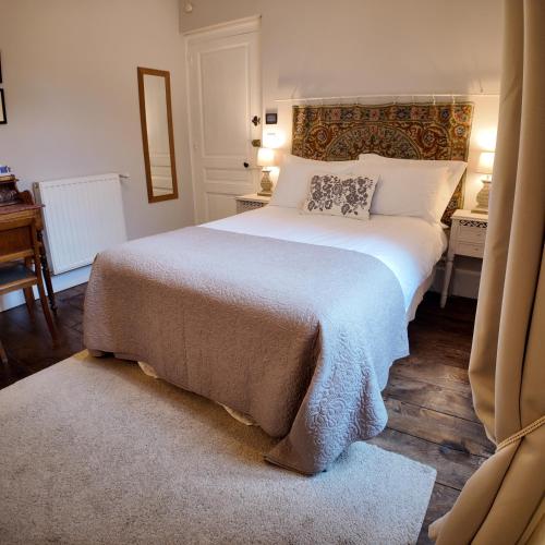 a bedroom with a large bed and a desk at Repos à Ribérac B&B in Ribérac