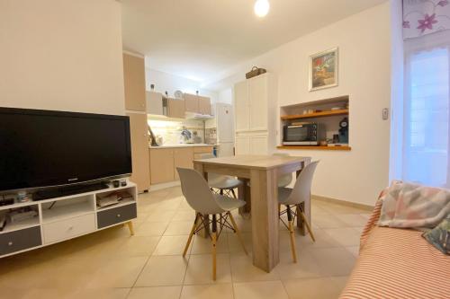 un salon avec une table avec des chaises et une télévision dans l'établissement bel appartement a vals les bains, à Vals-les-Bains