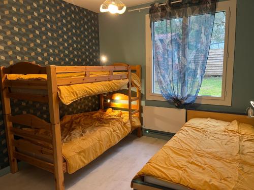 une chambre avec deux lits superposés et une fenêtre dans l'établissement Grande Maison à 150 mètres de La Plage, à La Tranche-sur-Mer