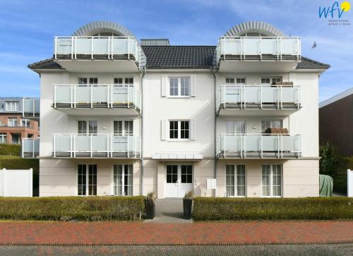 a large white building with balconies on it at Villa Verdi Ferienwohnung 1 in Wangerooge