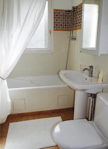 une salle de bain avec un lavabo, une baignoire et des toilettes dans l'établissement Domaine De Chantemerles, à Fontainebleau