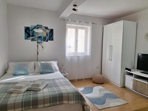 a bedroom with a bed with two towels on it at Rooms & studio OLD TOWN PAG in Pag